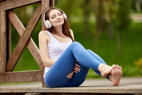 Frau mit drahtlosem Kopfhörer schloss beim Musikhören in der Natur die Augen. — Stockfoto