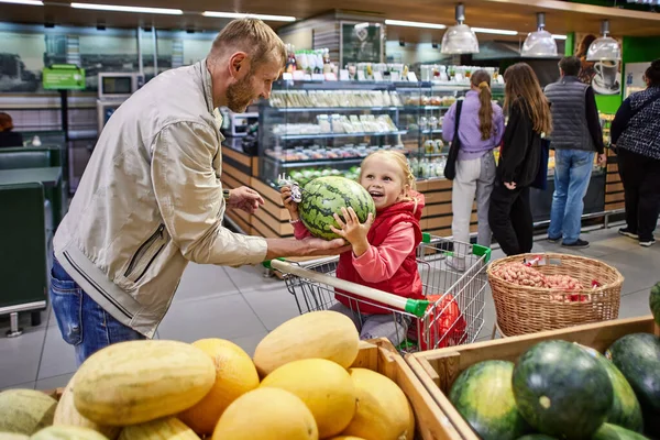 Far och dotter väljer vattenmelon i snabbköpet.. — Stockfoto