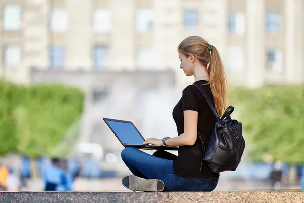 Fernarbeit oder E-Learning im Freien, junge Frau nutzt Laptop für Online-Bildung oder Telearbeit auf dem Stadtplatz. — Stockfoto