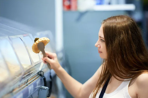 Joven mujer caucásica elige pasteles del supermercado. — Foto de Stock