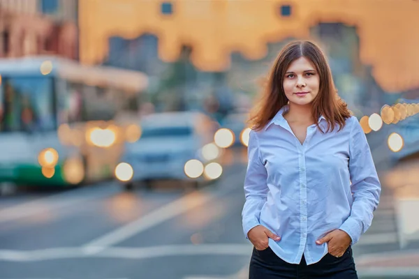 Mujer de 26 años se para cerca del tráfico con iluminación por faros de coches. — Foto de Stock