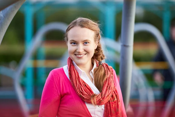 Portret van een glimlachende blanke vrouw op de speelplaats. — Stockfoto