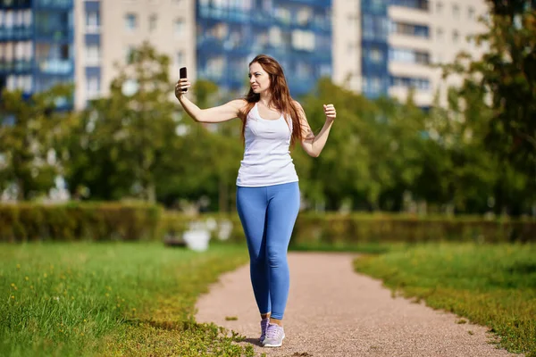 Młoda biała kobieta robi sobie zdjęcia joggingu za pomocą smartfona. — Zdjęcie stockowe
