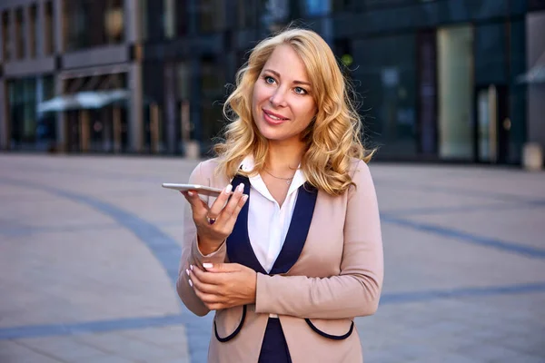 Takım elbiseli iş kadını hoparlör kullanarak akıllı telefonla konuşuyor.. — Stok fotoğraf