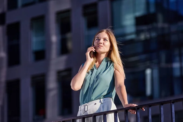 Női menedzser beszél telefonon közel üzleti központ. — Stock Fotó