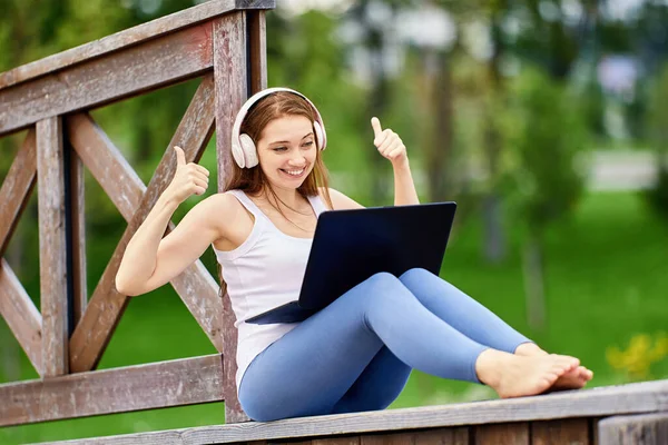 Online-Schulung von Frauen mit schnurlosen Kopfhörern im Freien. — Stockfoto