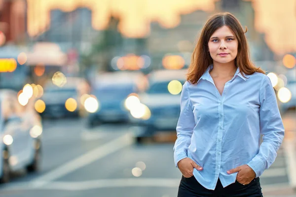 Mujer joven caucásica está de pie cerca del tráfico en la noche de verano. — Foto de Stock