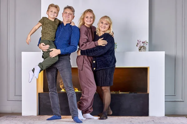 Friendly family is standing in living room near fireplace. — Stock Photo, Image