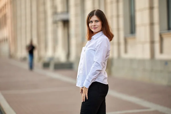 Smiling caucasian woman stands near historic building. — Stock Photo, Image