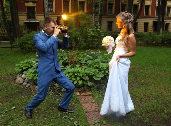 Fotograf ślubny biorąc obraz panny młodej, lampy błyskowej aparatu miga — Zdjęcie stockowe