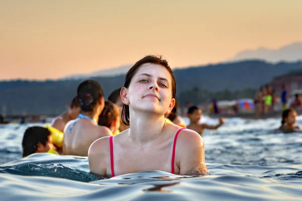 Young Caucasian girl bathes in the sea evening — Stock Photo, Image