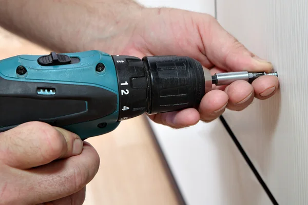 Cordless Screwdriver in the hands of joiner, close-up, screwing bolts. — Stock Photo, Image