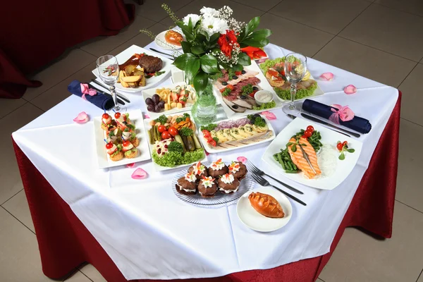 Table dressée avec une variété de plats, poissons, pâtisseries, cornichons — Photo