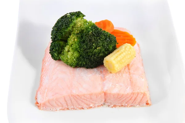 Piece of salmon on a plate, steamed, decorated with vegetables. — Stock Photo, Image