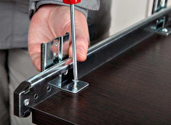 Assembling of furniture, install  drawer slides, screwing screw manual screwdriver. — Stock Photo, Image