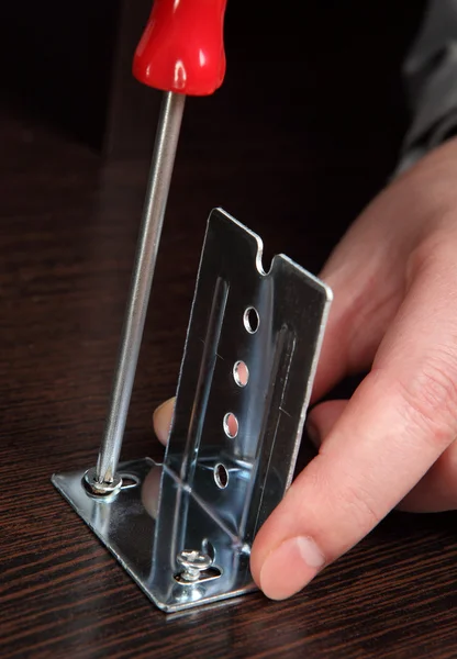 Fijación de herrajes de muebles, tornillos de tornillo con un destornillador de mano . — Foto de Stock