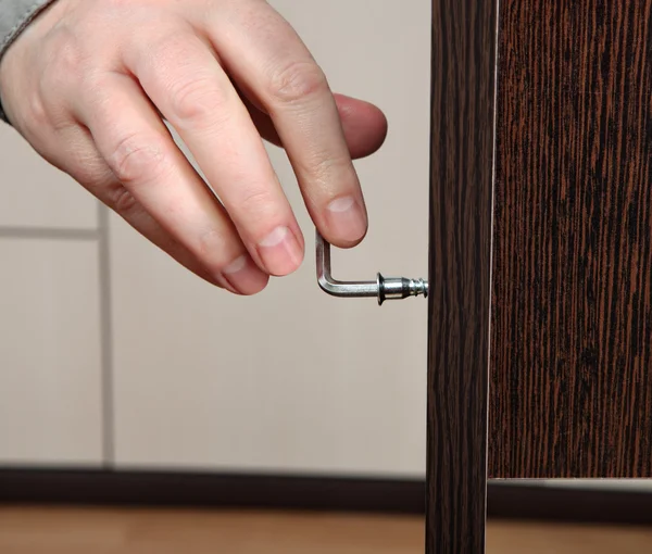 Close-up of a hand screw screwed hex wrench, assembling furniture. — Stock Photo, Image