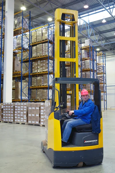 De bestuurder van een heftruck pallet, bereiken vrachtwagens. — Stockfoto