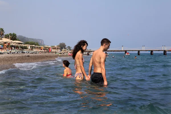 トルコのリゾート地、カップルの手を繋いでいる海水に深く行く — ストック写真