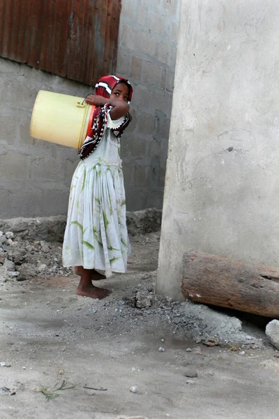 Moslim meisje is leeg gele plastic emmer, Zanzibar, fis — Stockfoto