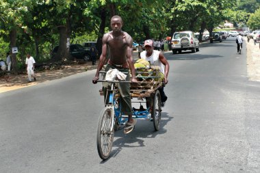 Afrika adam beden ile onun üç tekerlekli bisiklet sürmek.