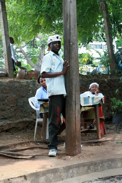 Afrikanischer junger Mann in Weiß, der am Rande der — Stockfoto