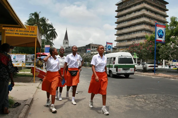 Quatre filles africaines noires en jupes orange et blouses blanches . — Photo