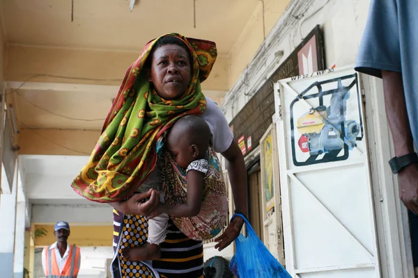 Black African mother with a baby in a sling. — Stock Photo, Image
