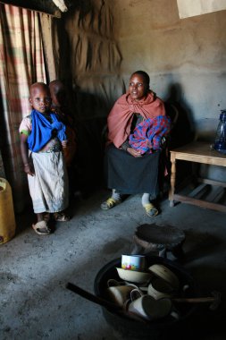 Masai aile içinde onların kulübe, siyah bir kadın ve çocuk.
