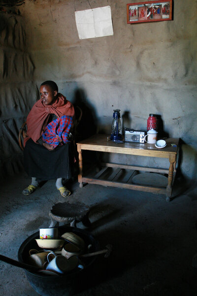  Internal view Masai home, black girl with baby are indoors.