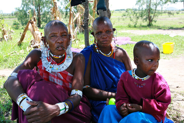 Family Maasai tribe, two women in draped robe, and  child.
