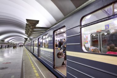 Mavi tren platformu Metro İstasyonu'na ayakta yolcu ile