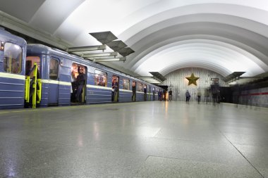  Passenger platform at a subway station, train with blue wagons. clipart
