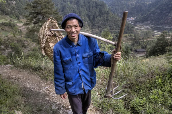 Asian peasant goes to work in fields with  hoe fork. — Stock Photo, Image