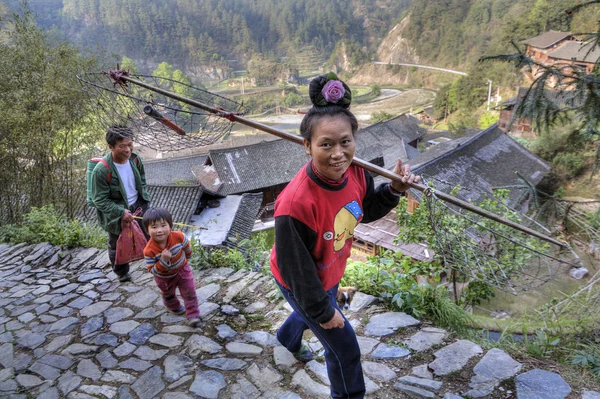 Asian woman carrying a yoke — Stock Photo, Image