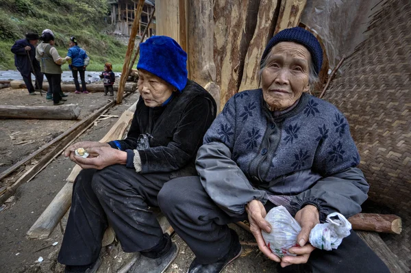 Due contadini asiatici anziani, donne rurali, seduti vicino alla casa contadina — Foto Stock