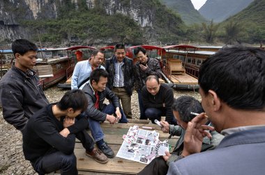 Çinli erkekler, pier, Guangxi, China yakınındaki boatmen iskambil oyunu