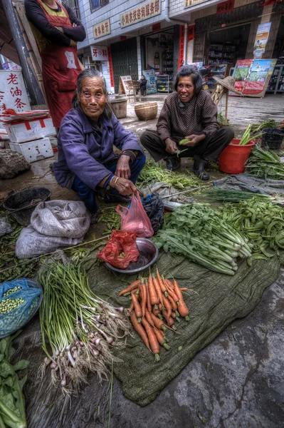Chłop chiński kobiety sprzedaży produktów rolnych na rynku village, — Zdjęcie stockowe