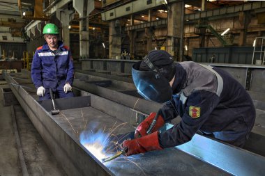 İşçi Kaynakçı el ile çelik levha gaz Meşalesi, Mig kullanarak kaynak.