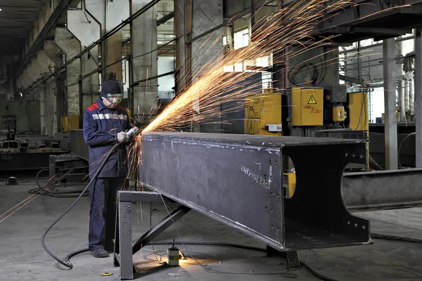 Metalworkers polishing welds metal structures, producing fountain of sparks. — Stock Photo, Image