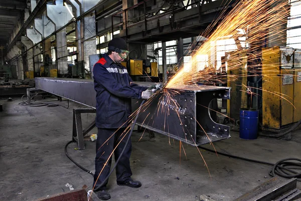 Metallarbeiter schleift Schweißstahlprofile mit einem Winkelschleifer. — Stockfoto