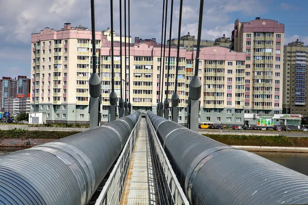 Zavěšený most s vytápěním hlavní, přes řeku v bytové — Stock fotografie