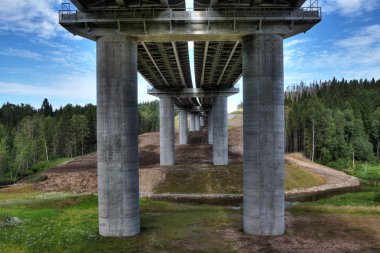 Bitmemiş çelik yolu köprüsü üzerinde beton sütunlar, haçlar yatak akışı.