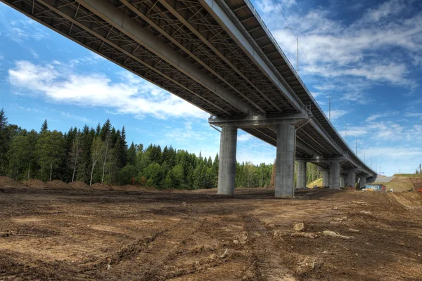 Vista inferior sobre vãos de ponte de estrada de aço em suportes de concreto . — Fotografia de Stock