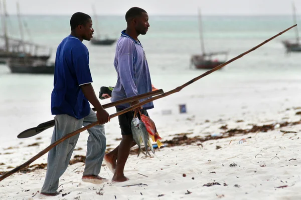 Dos buceadores africanos llevan pescado capturado a casa . — Foto de Stock