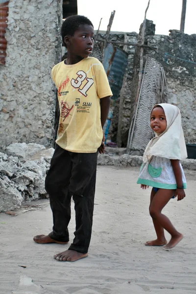 Bambini africani a piedi nudi camminano lungo il villaggio di pescatori, Zanzibar, Tanzania . — Foto Stock