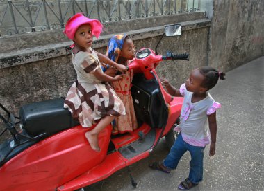 Afrika park edilmiş kırmızı scooter oynayan üç küçük kız.