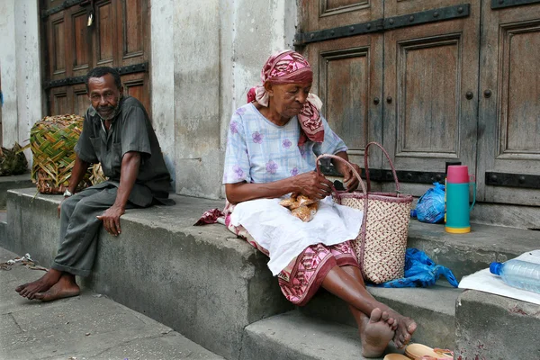 African street traders sit at the of closed Trade Rows. — Stock Photo, Image