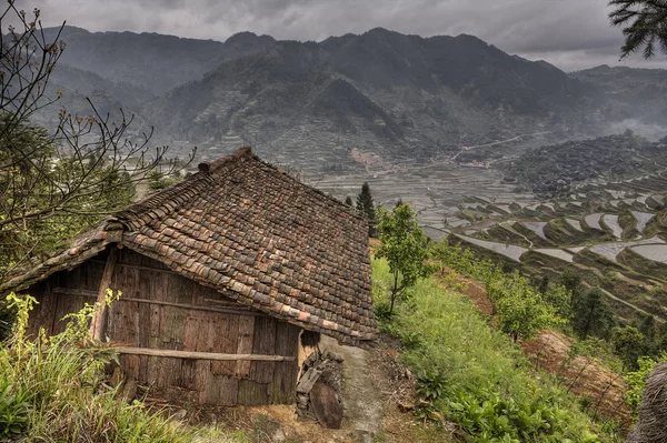 Wooden shed farmers in highlands of China, amid rice fields. — Stockfoto