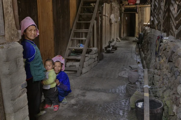 Two Chinese women and child, in courtyard of their house. — Stock Photo, Image